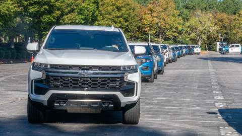 A white pick up truck followed by many Raleigh police cruisers lined up ready to travel to western NC to help with recover efforts after Hurricane Helene