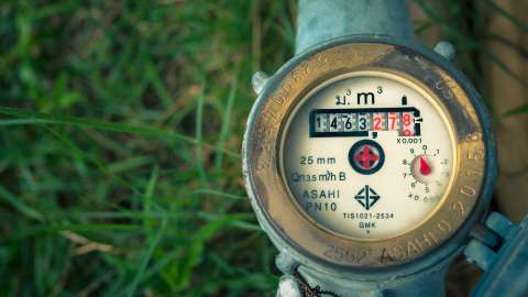 A water meter with grass in the background