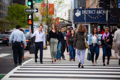 This shows many people crossing a street.