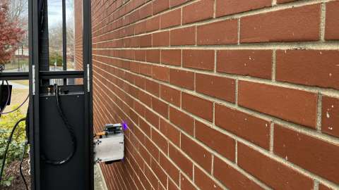 Commercial printer on a structure printing directly on a brick wall.