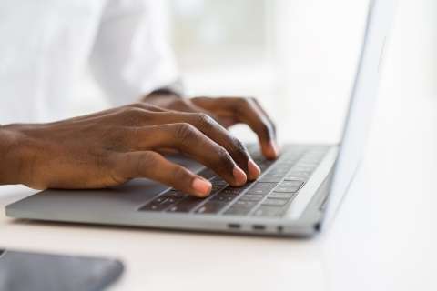 Close up of a person typing on a keyboard