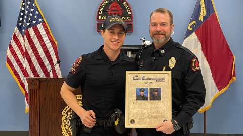 Officer Mills is presented with a poster of the bulletin honoring his heroics.