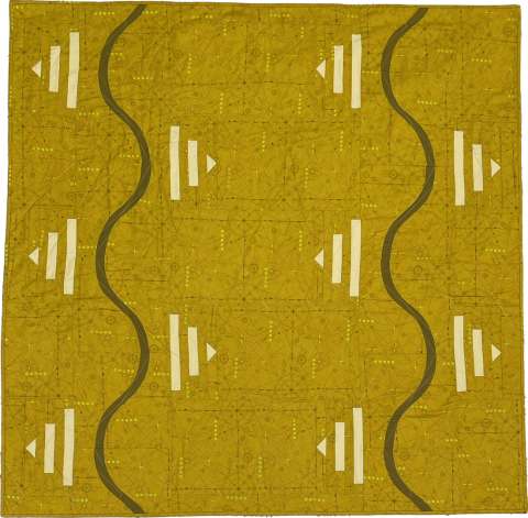 Detail of mustard colored quilt with black lines and white triangles