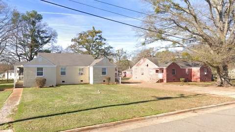 Photo of two duplex buildings with tree in the front yard of one of the buildings