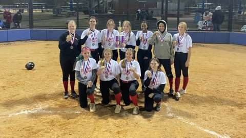 a group of girls winning champs for softball