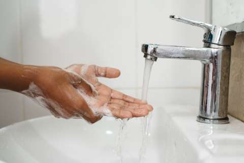 Hands with soap over sink