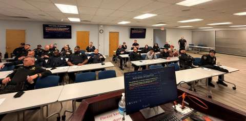 Police officers sitting at conference room desks
