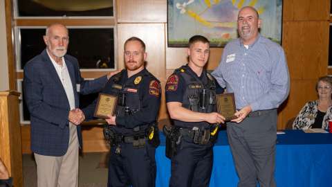 Two RPD officers receiving awards and shaking hands