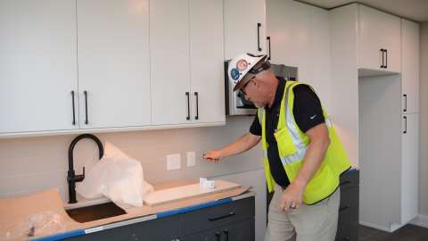 Building safety inspector checking electrical outlet.