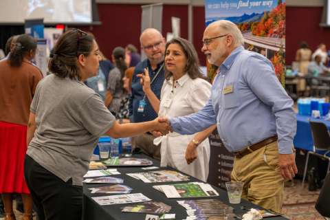 Two people shaking hands at networking event