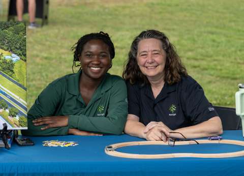 two women smiling behind table
