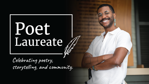 A smiling young, black male poet in a white shirt and octagonal wire rimmed glasses, stading with his arms crossed.