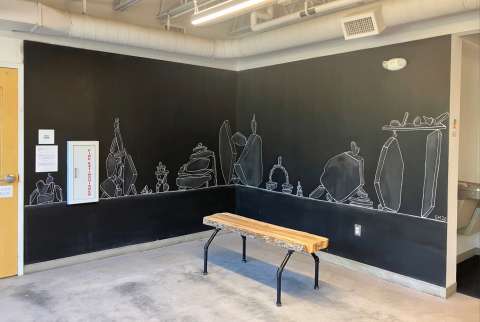 Corner chalk wall with white chalk drawings of piles of rocks