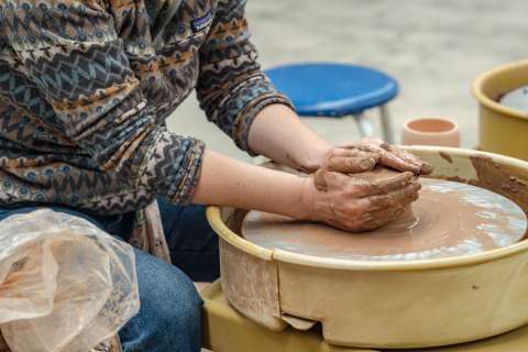 Woman throwing a pot on the wheel