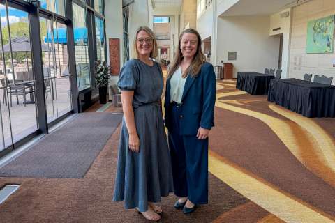Two staff members smiling inside performing arts center
