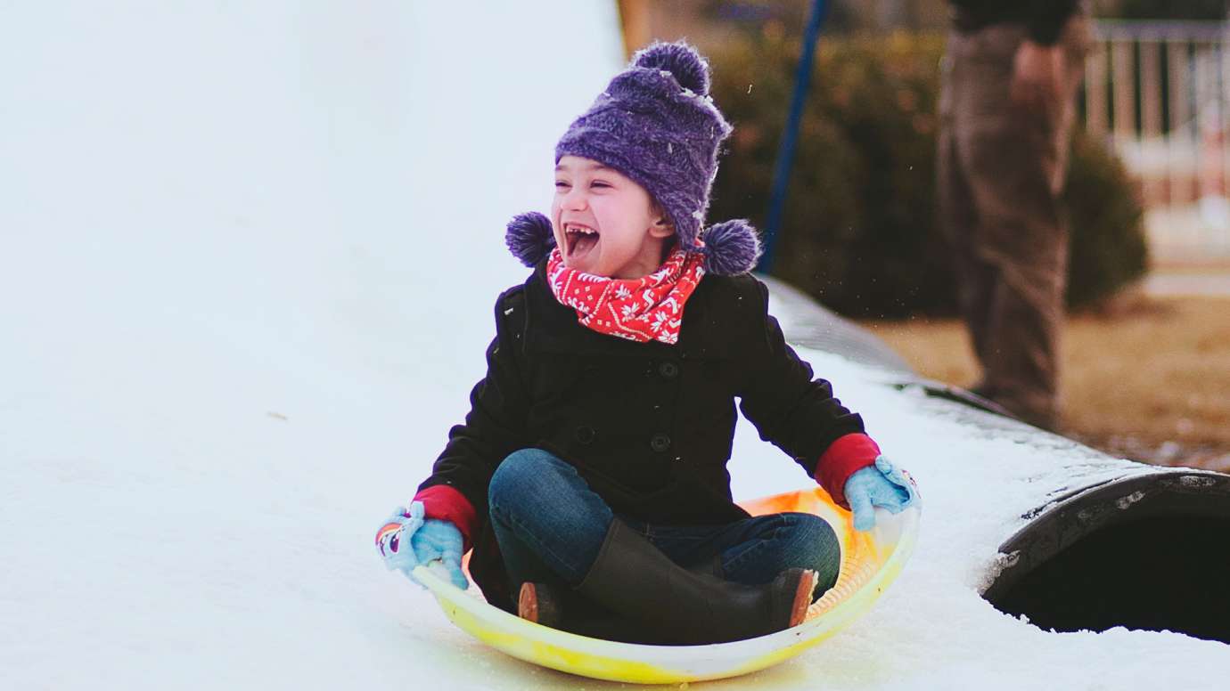 Little girl sledding at Holiday Express event