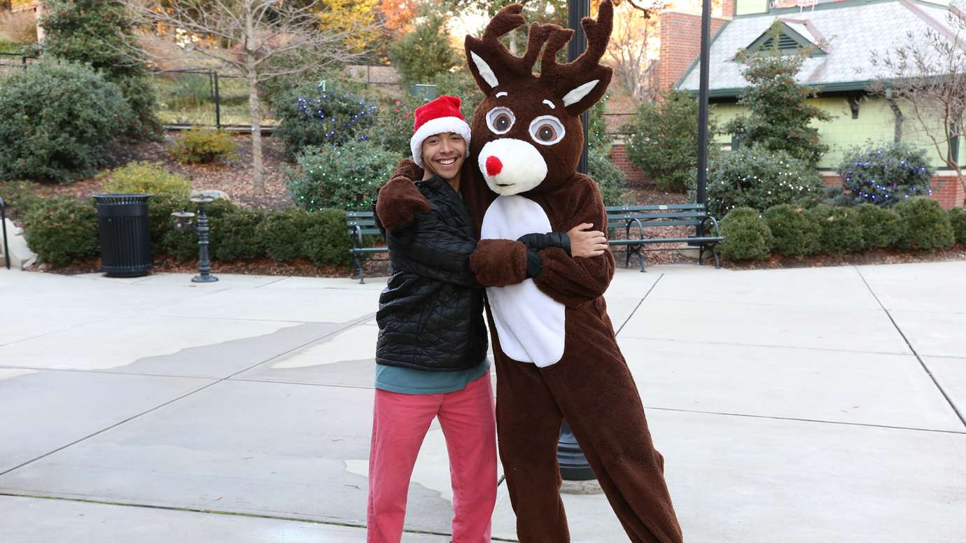 Staff next to reindeer mascot at Holiday Express event