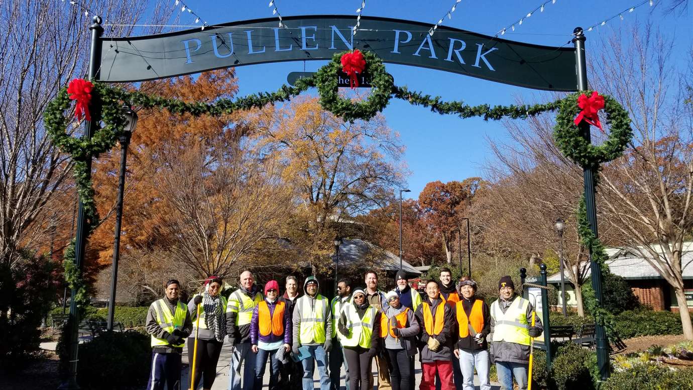 Group of Holiday Express event volunteers under Pullen Park sign.