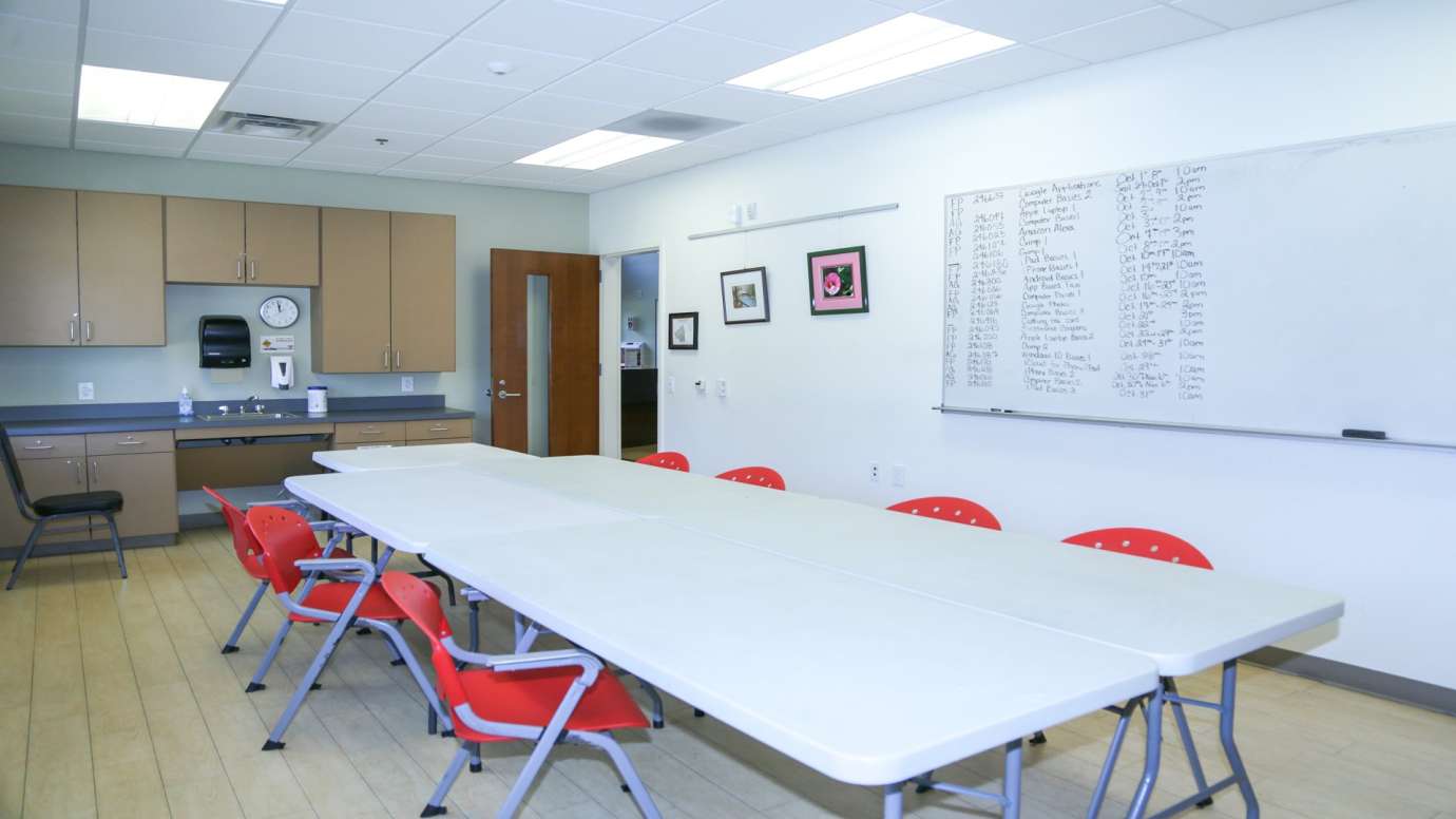 A second classroom with counter space, a white board, a table and chairs 