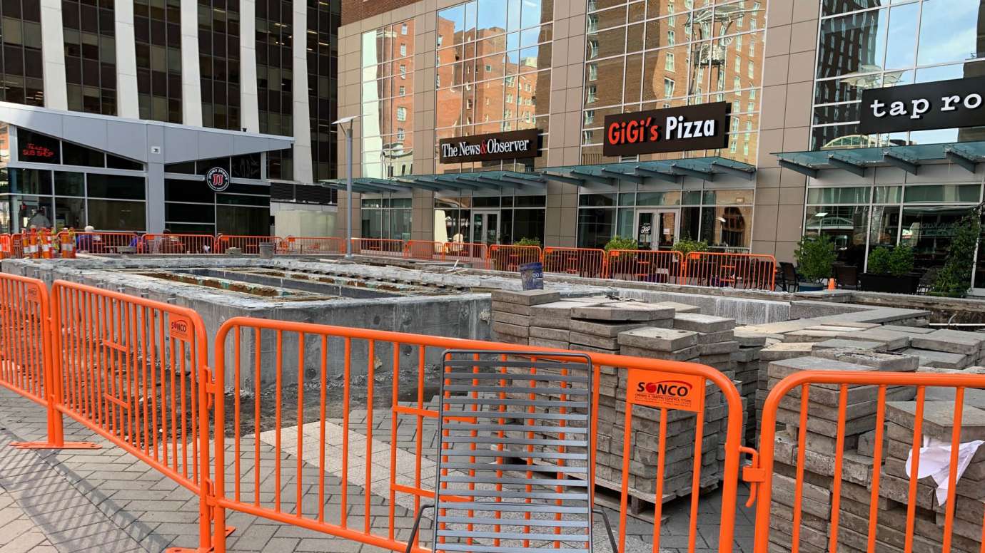 An orange metal construction fence in City Plaza that's surrounding the fountain that will be removed.