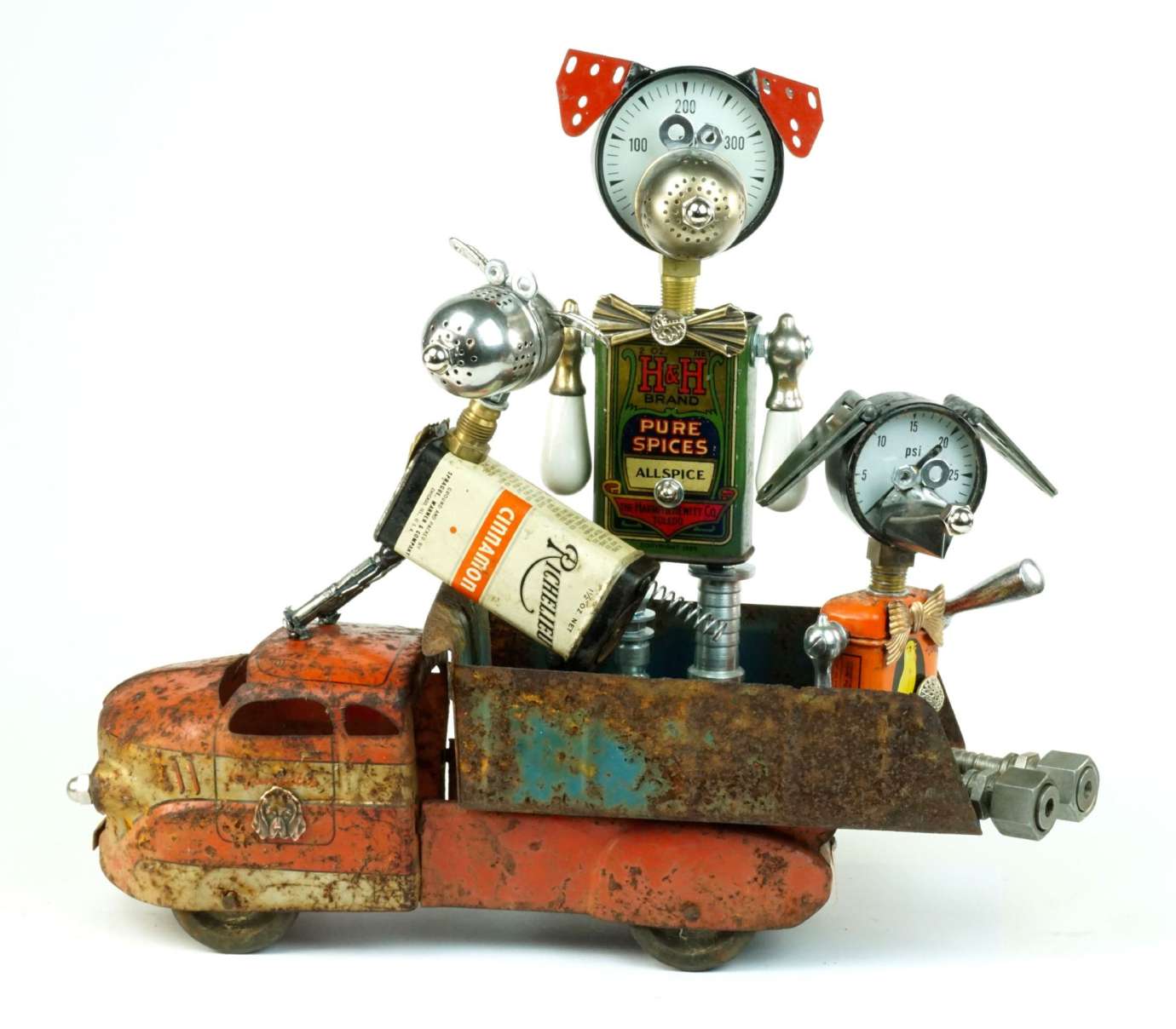 A sculpture of a person and two dogs riding in a truck made from found objects by artist Amy Flynn