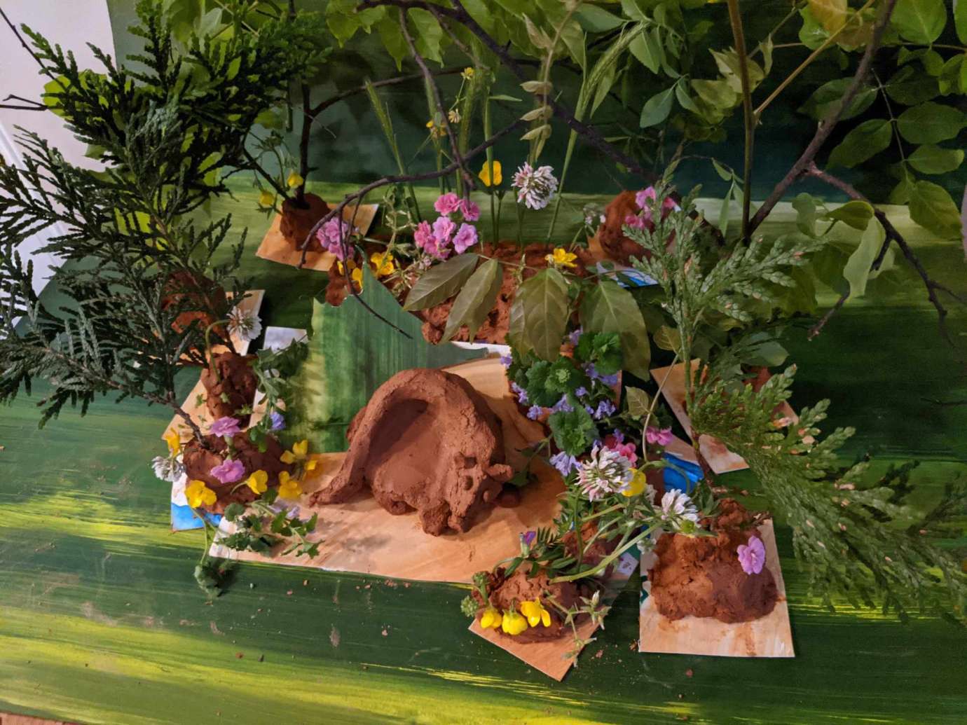 A diorama of a sleeping creature surrounded by flowers and leaves