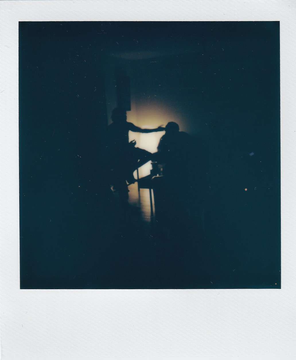 Polaroid photography by I'Nasah Crockett, silhouette with their arm outstretched towards another
