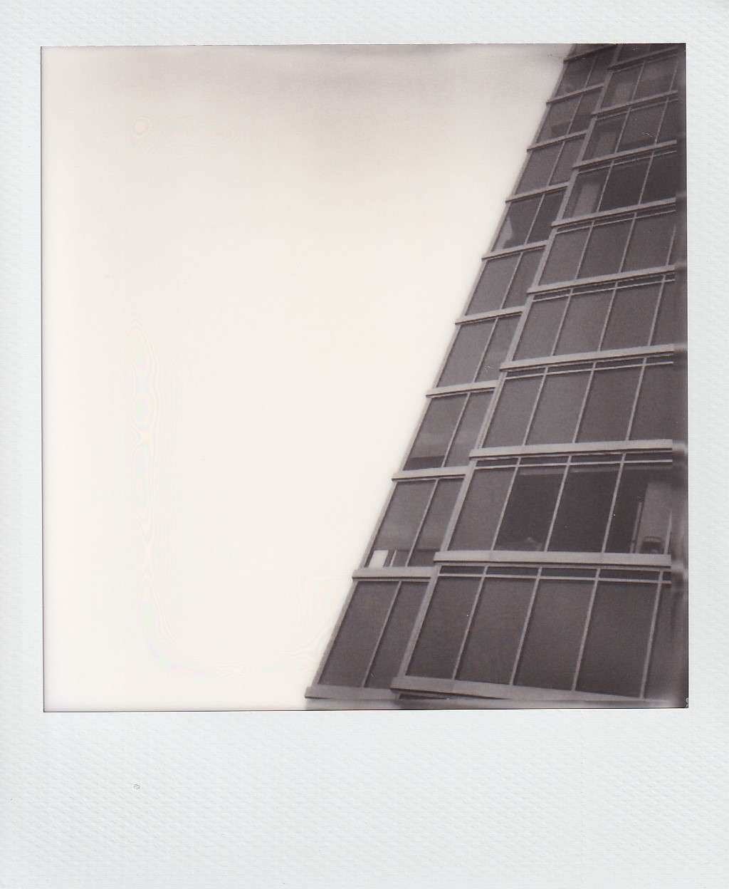 Polaroid photograph by I'Nasah Crockett, windows of a skyscrapper against the sky