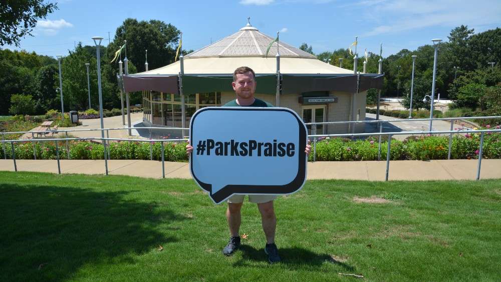 Parks staff holding sign in front of Chavis carousel