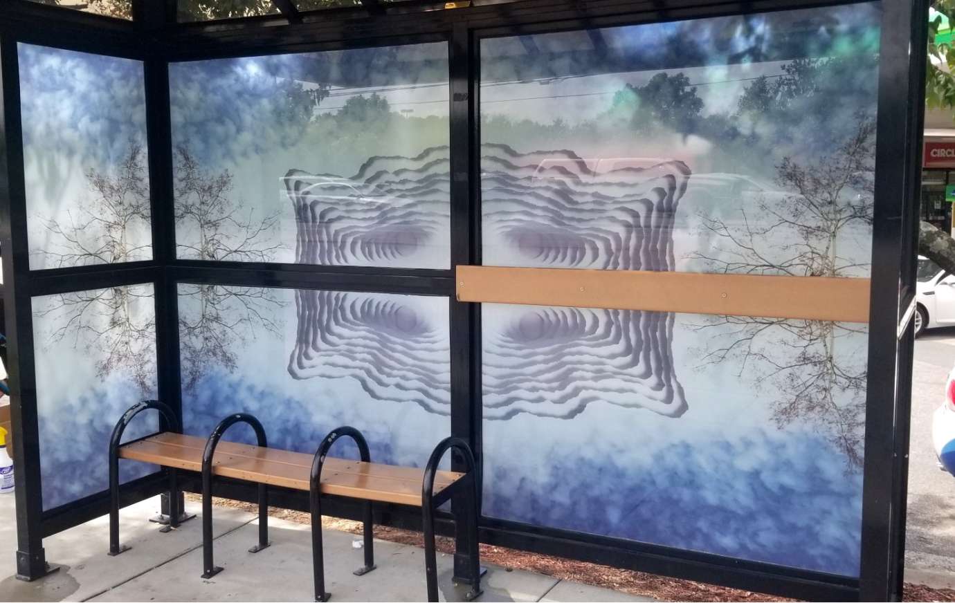 artwork by Scott Hazard covering the windows of a bus shelter