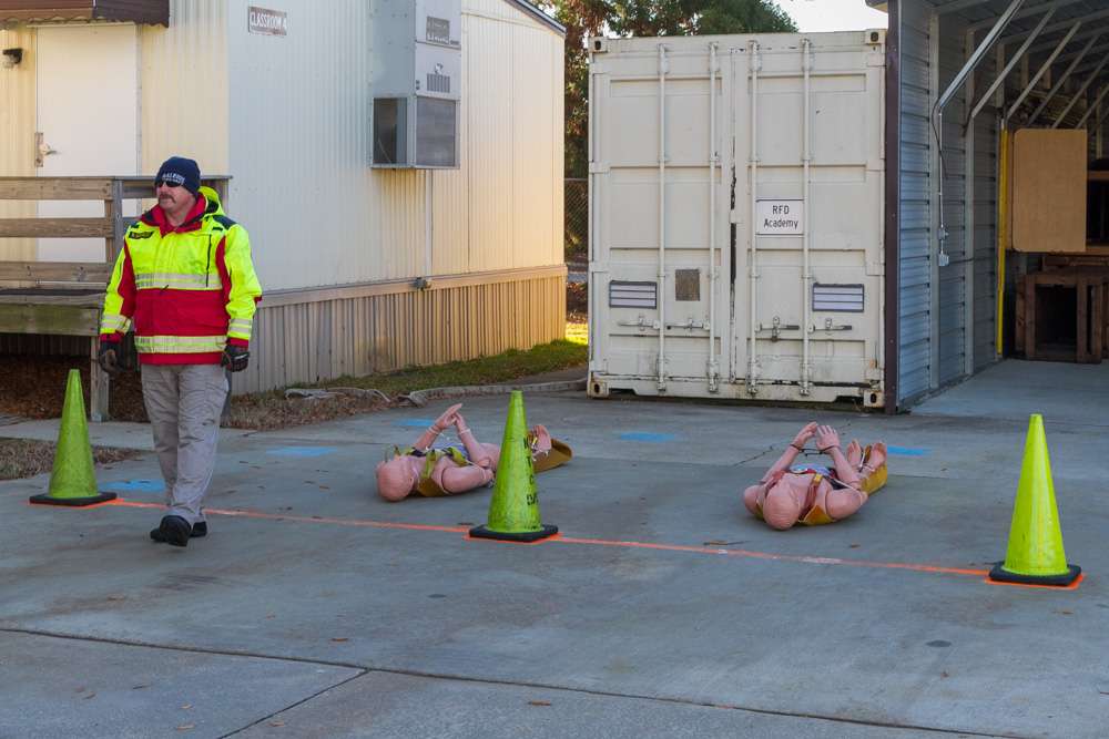 Firefighter stands next to rescue dummies