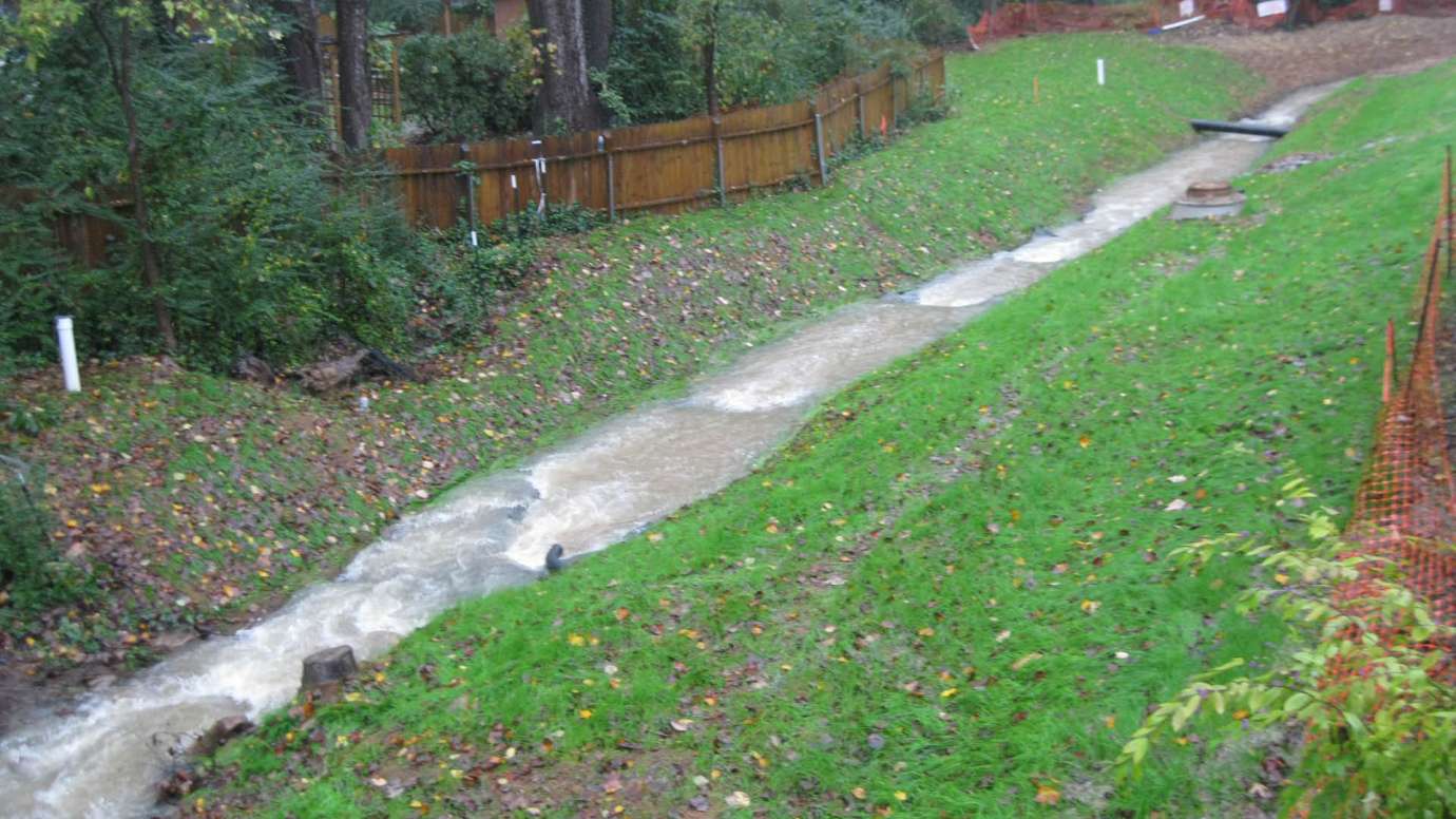 A stream in a backyard on Rainwood Lane flowing to a new stormwater culvert