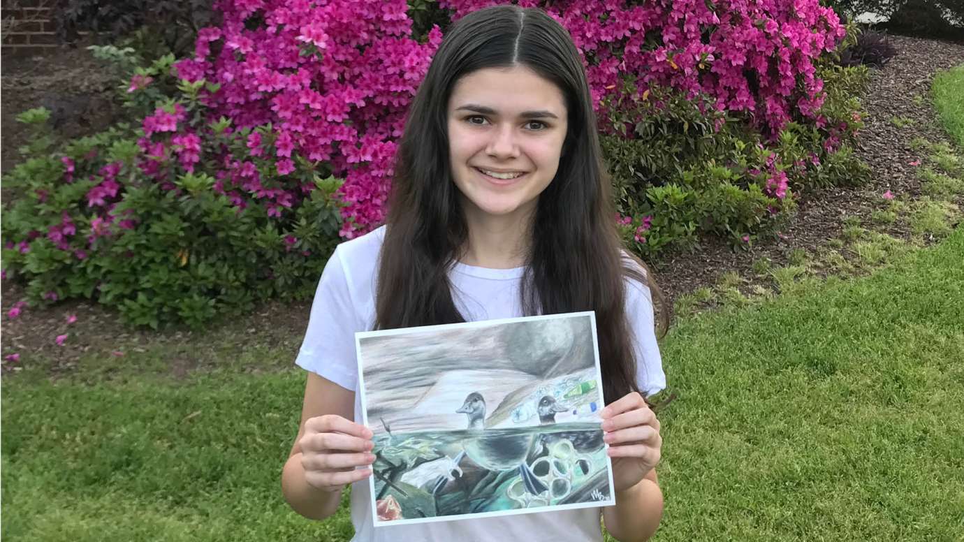 Mackenzie Book holding the drawing that she created for our stormwater contest. 