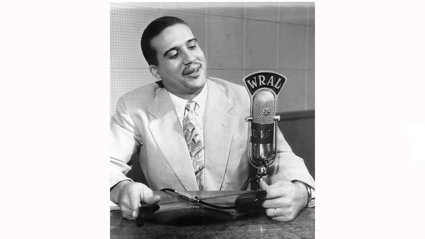 Black and white historic image of man holding old microphone