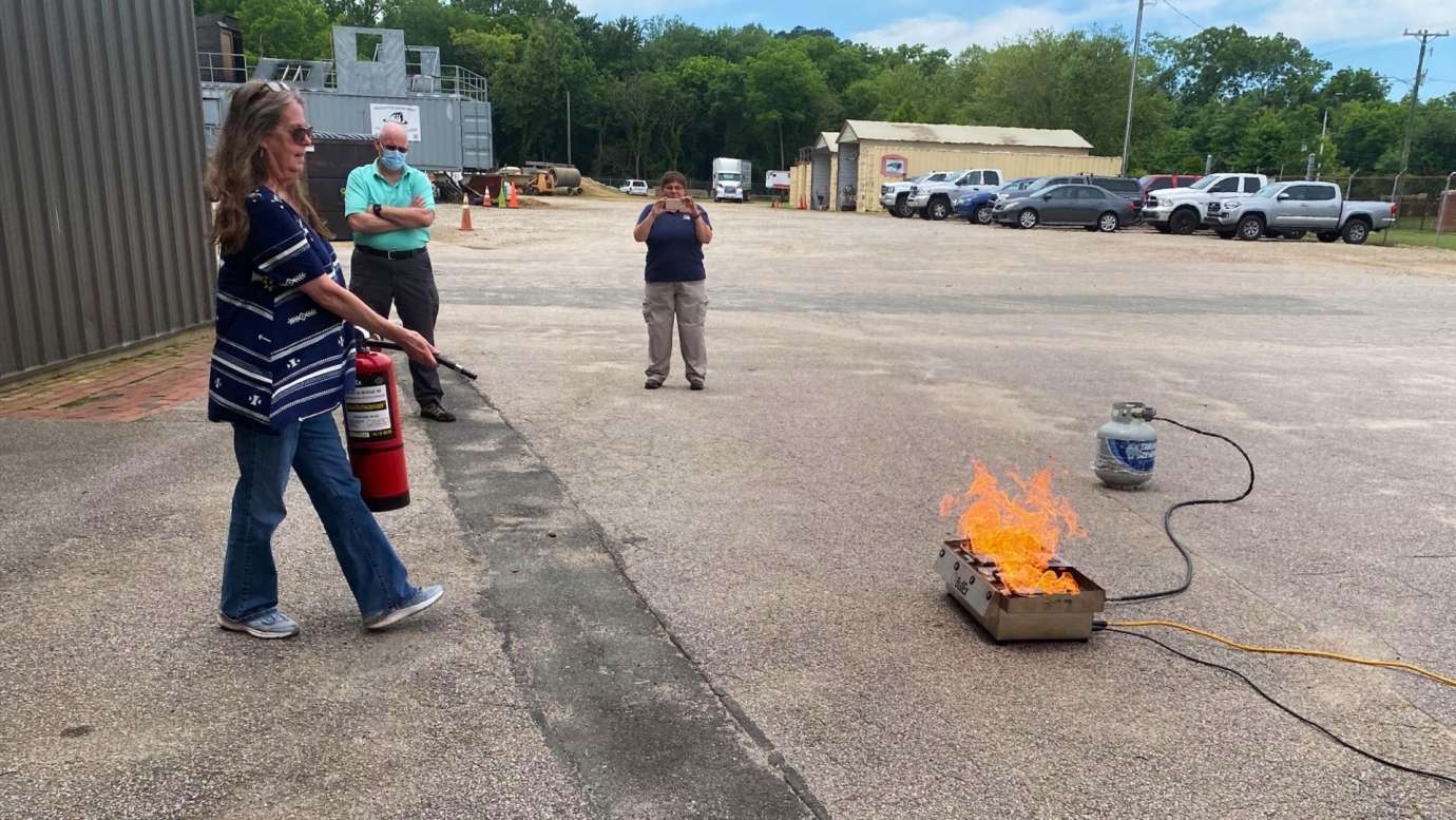 Woman uses a fire extinguisher during CERT training