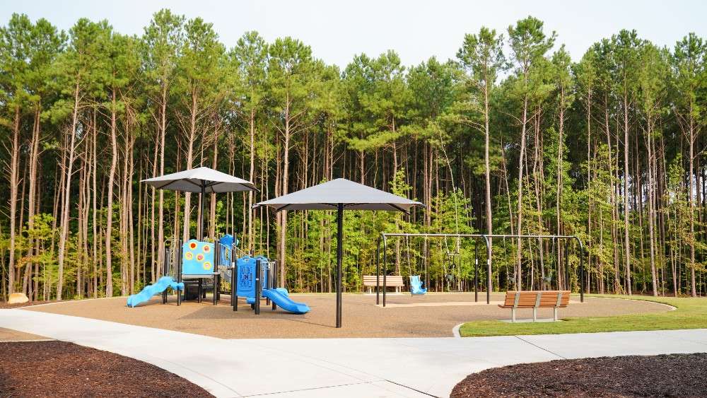 Playground structure for smaller kids with small slides, umbrella shades and swings