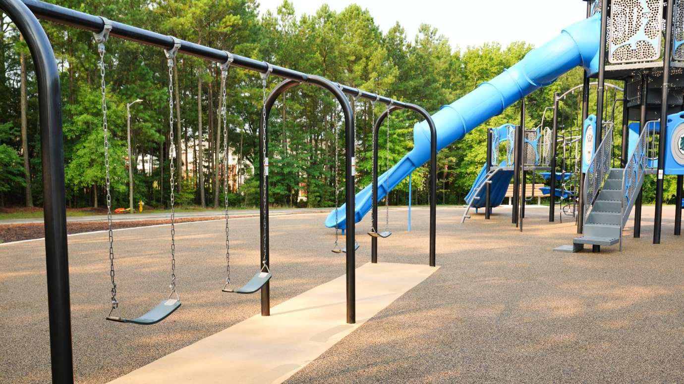 Swings on playground with play structure in background