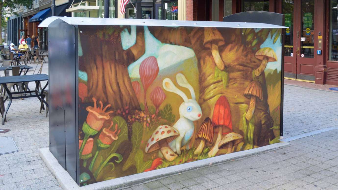 Artwork on a news rack kiosks that depicts a rabbit in an autumn forest setting