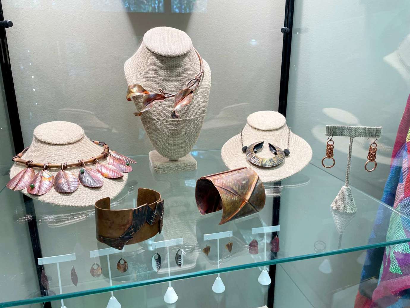 Handmade necklaces and bracelets in a display case by Katherine Cherry
