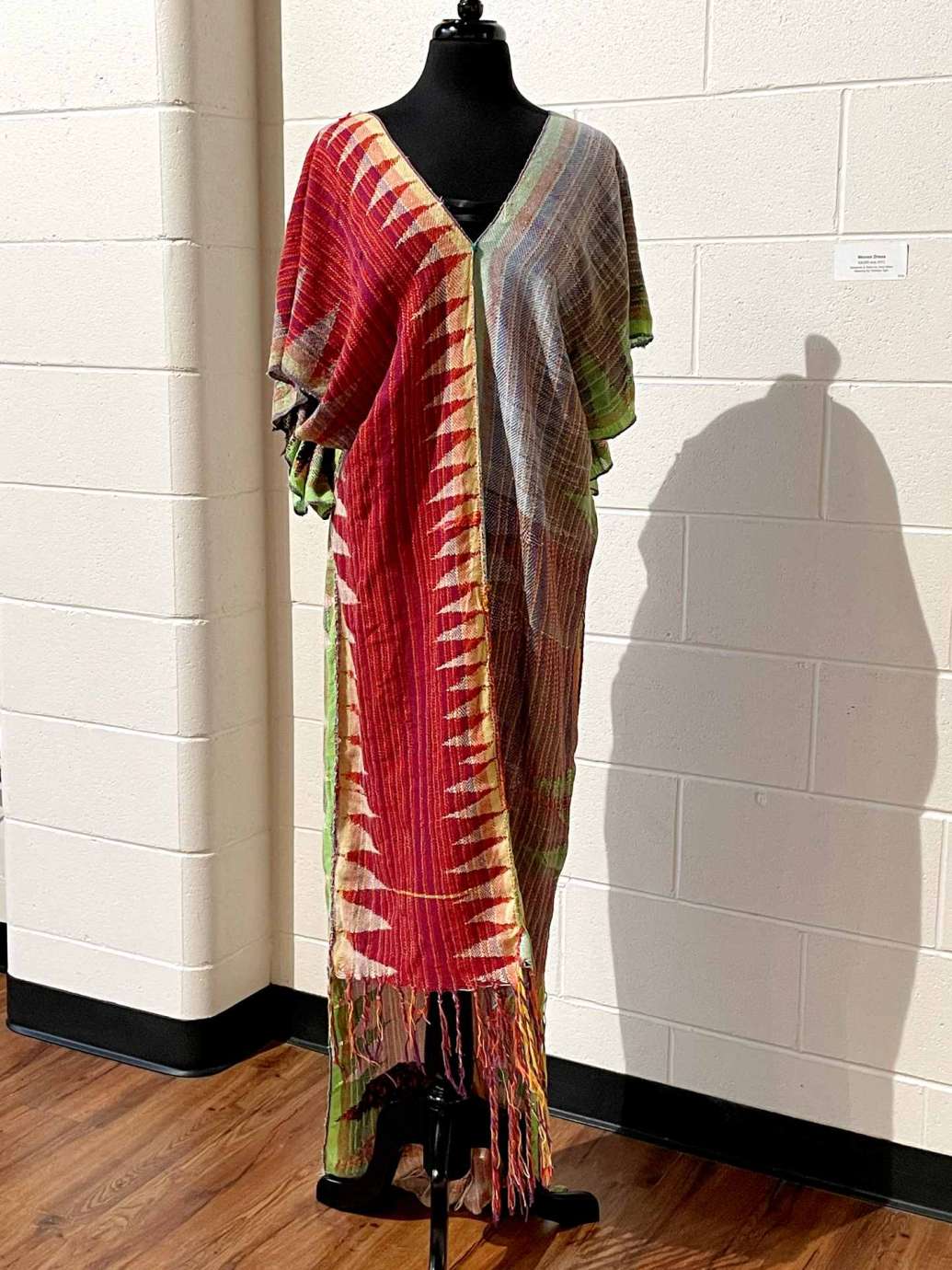 A woven dress hanging on a mannequin 