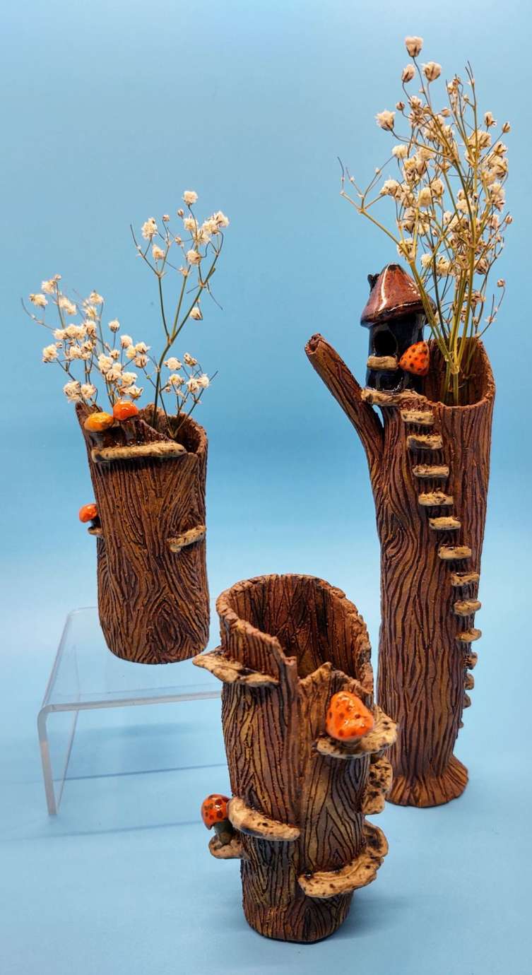 A set of three ceramic vases that resemble logs