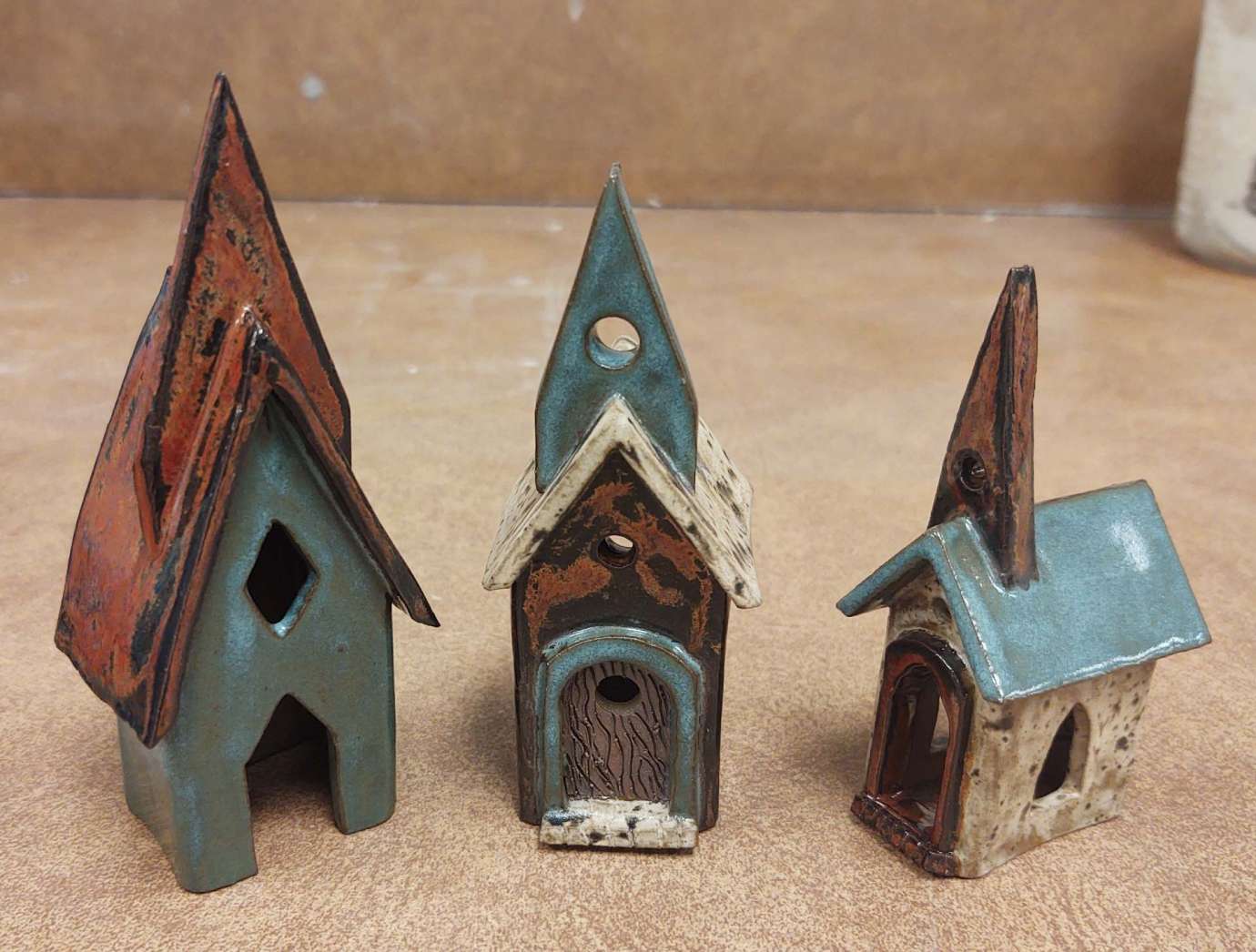 a set of three ceramic churches with colorful steeples