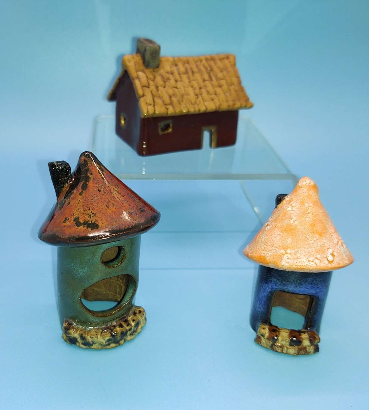 A photograph of three small ceramic houses