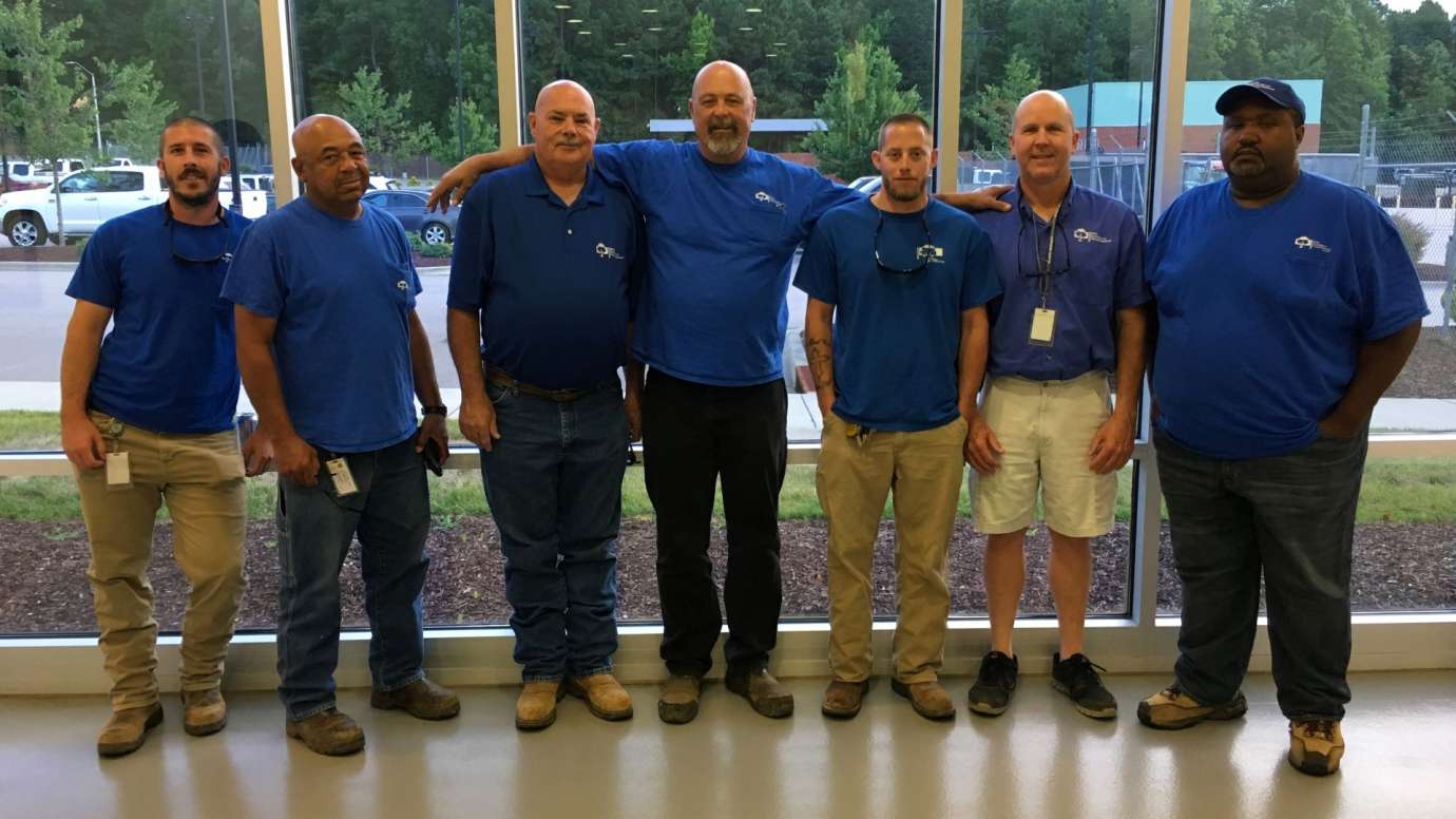 Group of men in Parks blue shirts smiling