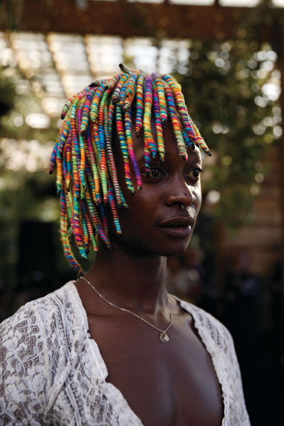 A photograph of a woman with colorful thread wrapped in her hair by artist Samantha Everette