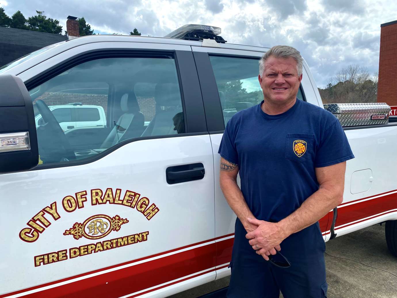 Firefighter Brett Taylor standing in front of RFD truck
