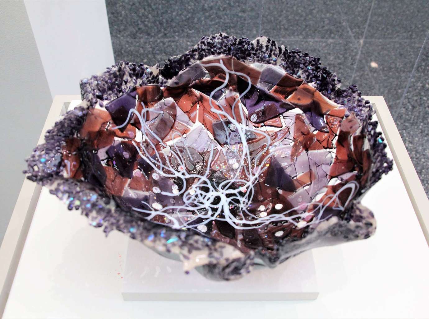 A bowl made from layers of folded glass in different shades of purple