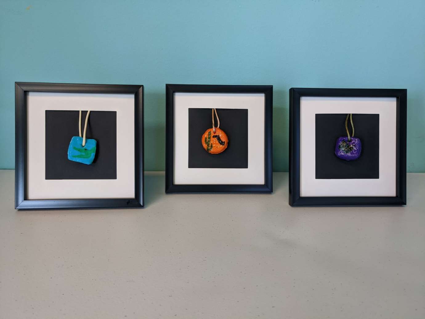 Multiple framed pendant necklaces made by members of the Abound Health Day Program