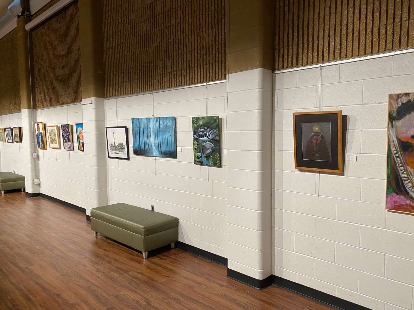Several art pieces hang from the wall at Sertoma Art Center