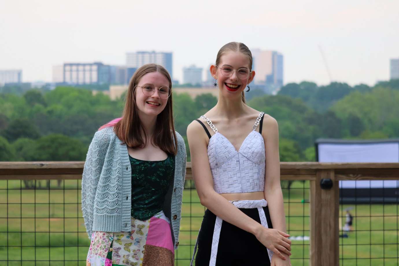 Two girls pose in front of Raleigh skyline